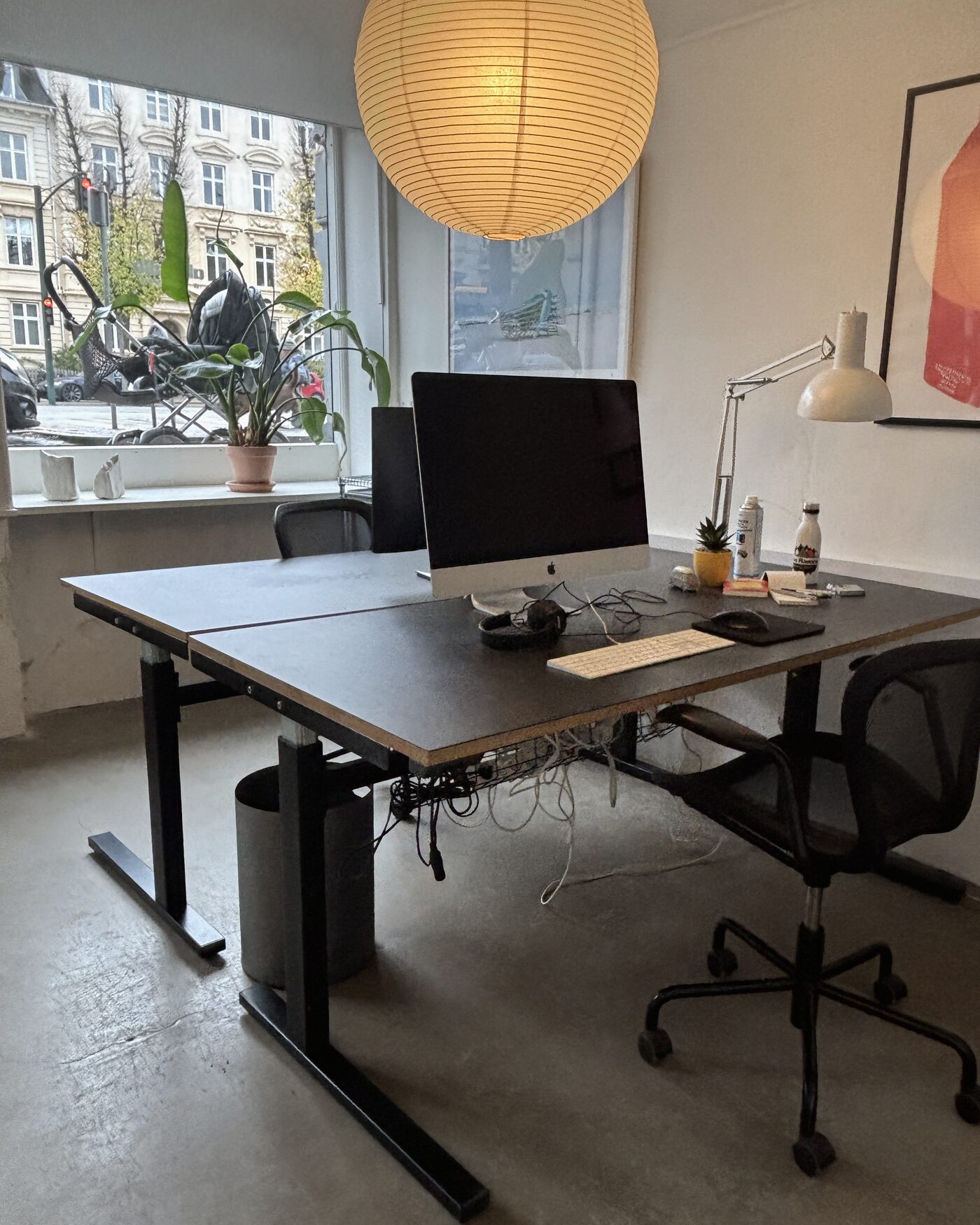 Skrivebord med iMac, høretelefoner og skrivebordslampe